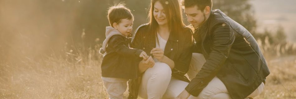 A cheerful family bonding outdoors with a soccer ball, enjoying a sunny day in the grass.
